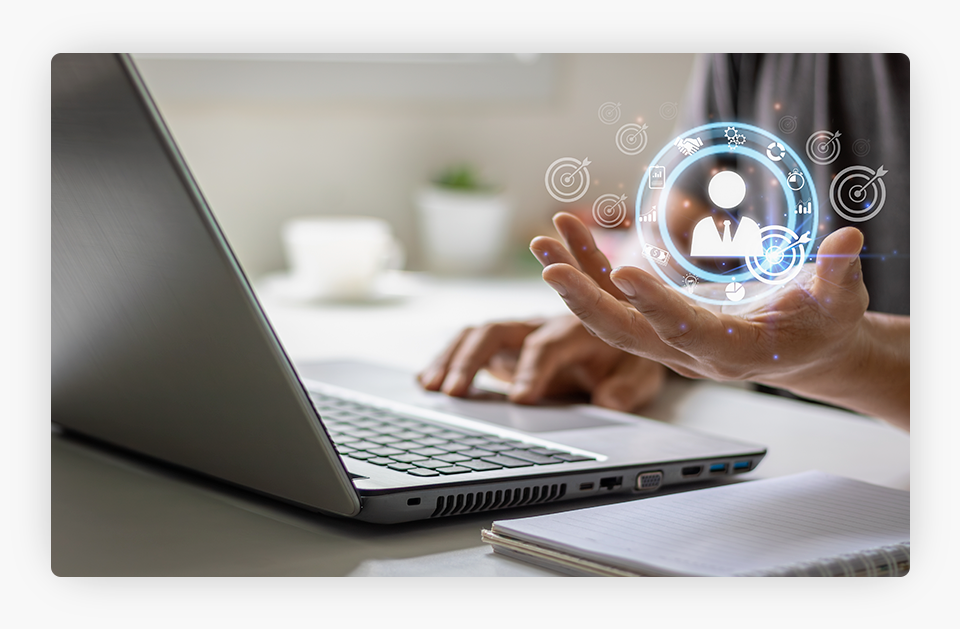 Un hombre con una computadora portátil, sosteniendo un ícono digital flotante con su mano izquierda.