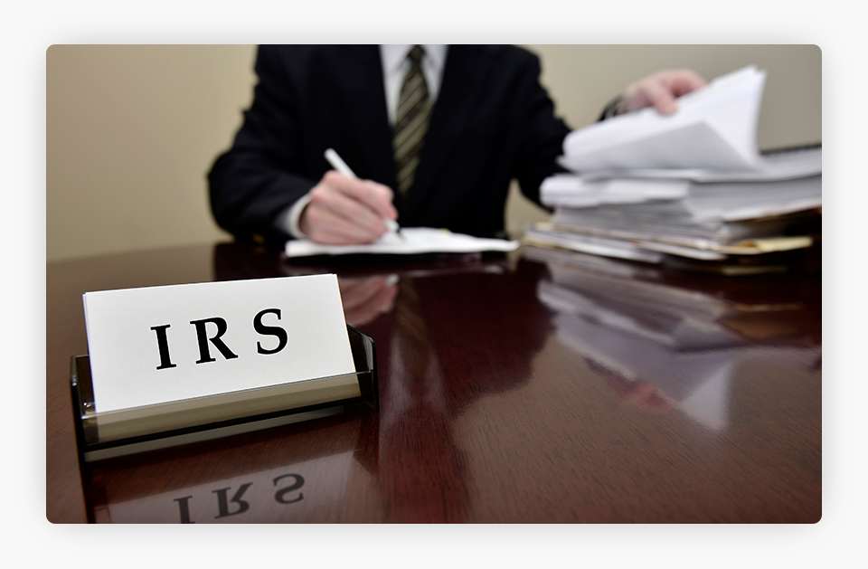 Hombre auditor fiscal del IRS con un cartel del IRS delante.