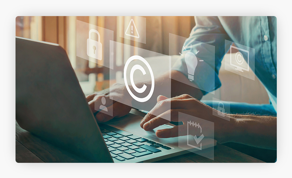 Una persona trabajando en un ordenador con el icono de copyright en él.